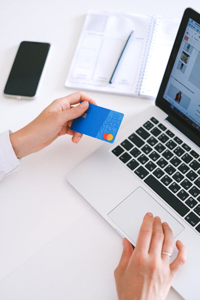 The Art of Drawing Readers In: Your attractive post title goes here Person making an online purchase with a credit card on a laptop, showcasing modern ecommerce technology.