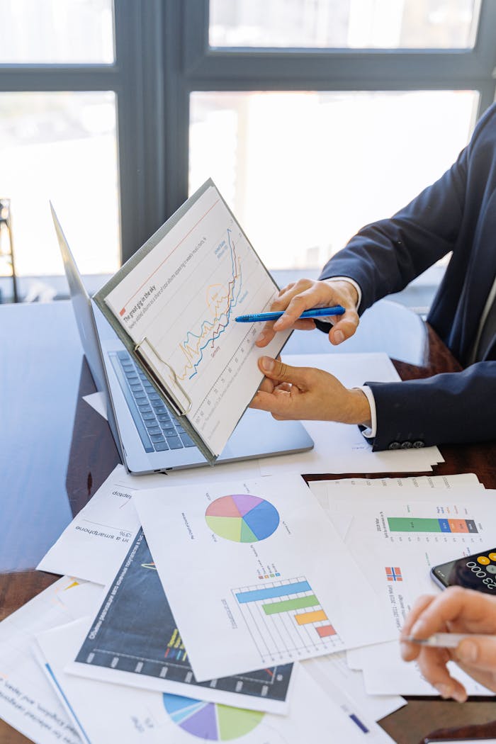 about-us Business professionals discussing financial graphs and charts in an office setting.